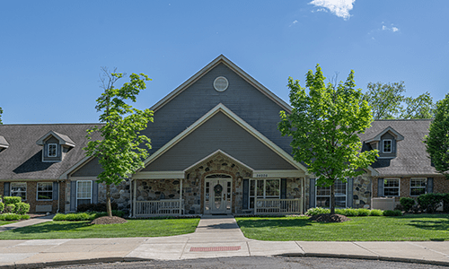 A suburban residential building with an inviting entrance surrounded by greenery.