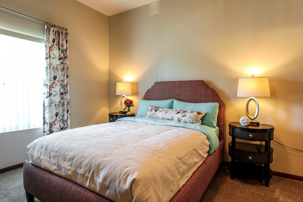 A cozy bedroom with soft lighting and comfortable bedding.