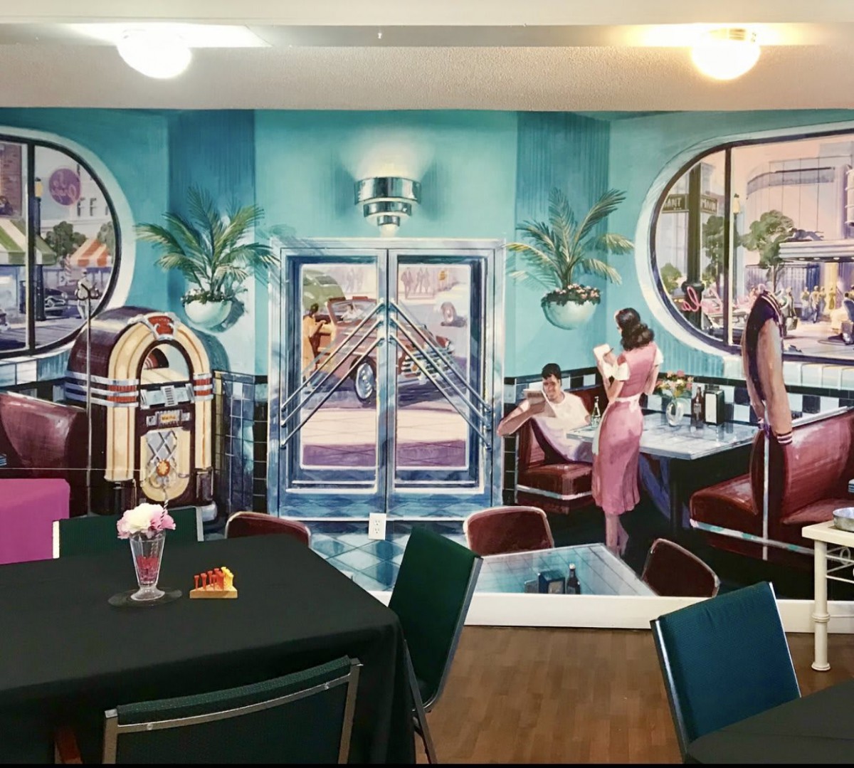 A retro-style diner with a colorful mural and classic decor reminiscent of the 1950s.