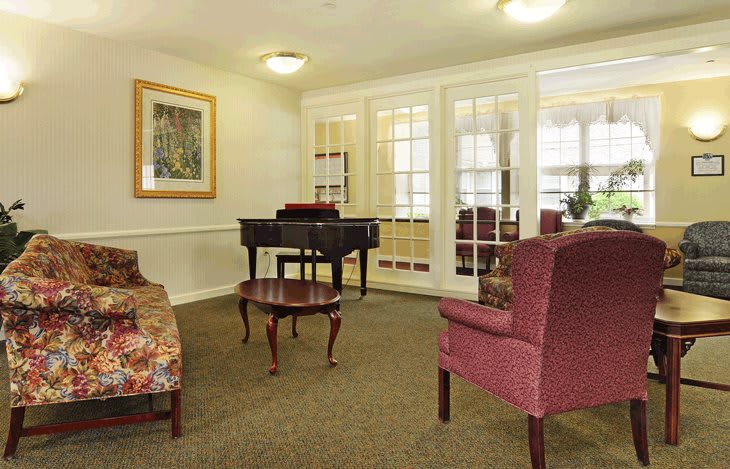 A cozy living room with a piano and comfortable seating.