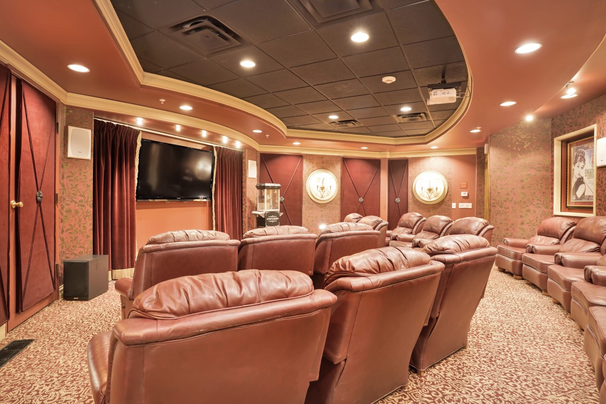A luxurious home theater with plush reclining seats and a large screen.