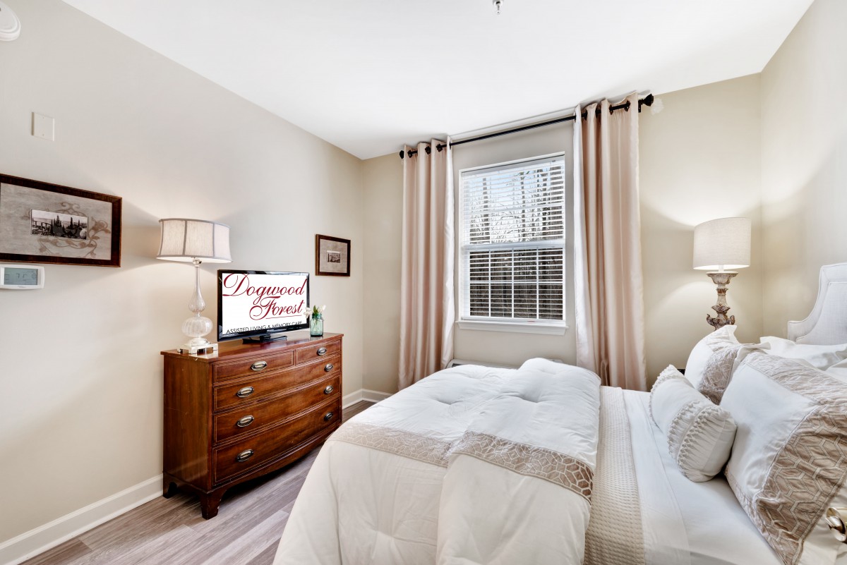 A cozy bedroom with a bed, dresser, and window adorned with curtains.