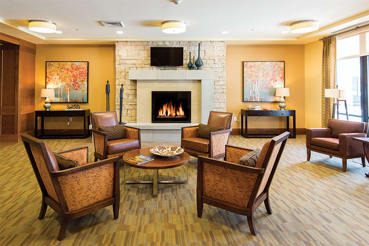 A cozy living room with a central fireplace and comfortable seating.