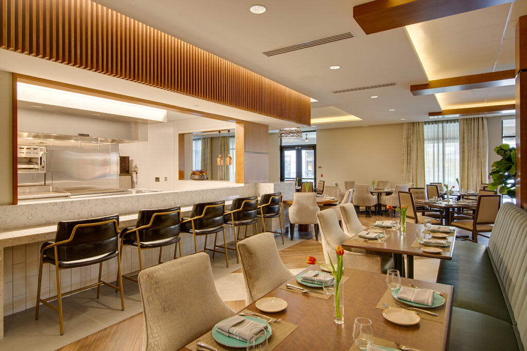 A modern restaurant interior featuring a cozy dining area with elegantly set tables.