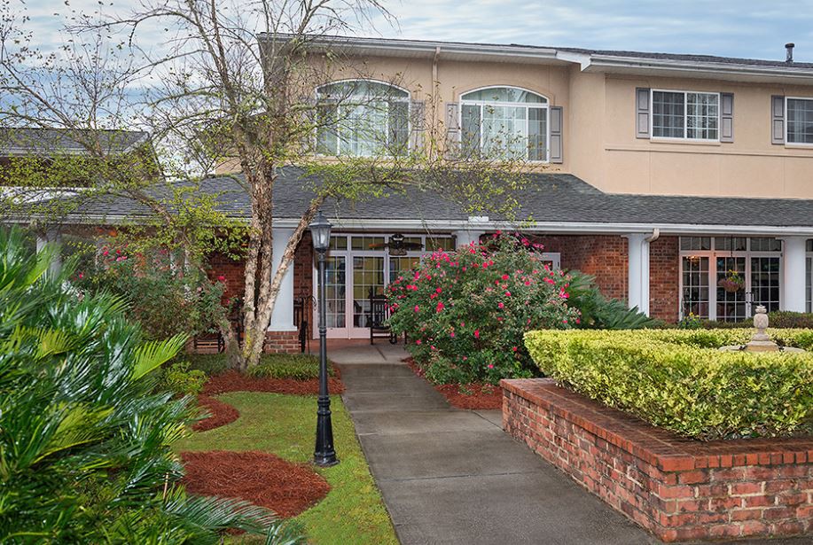 A two-story house with a landscaped front yard and brick accents.