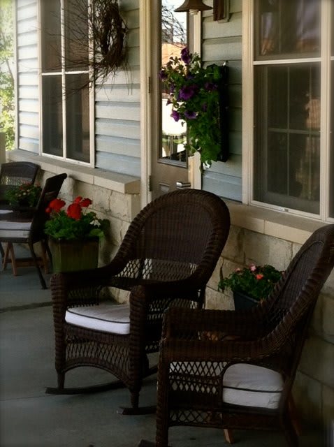A cozy porch with wicker chairs and potted flowers.
