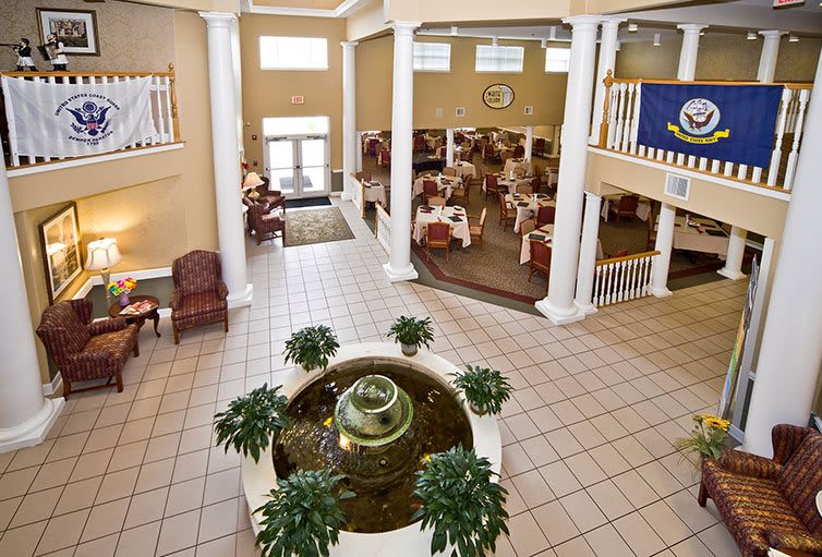 Spacious lobby interior featuring a central fountain surrounded by plants and seating areas.