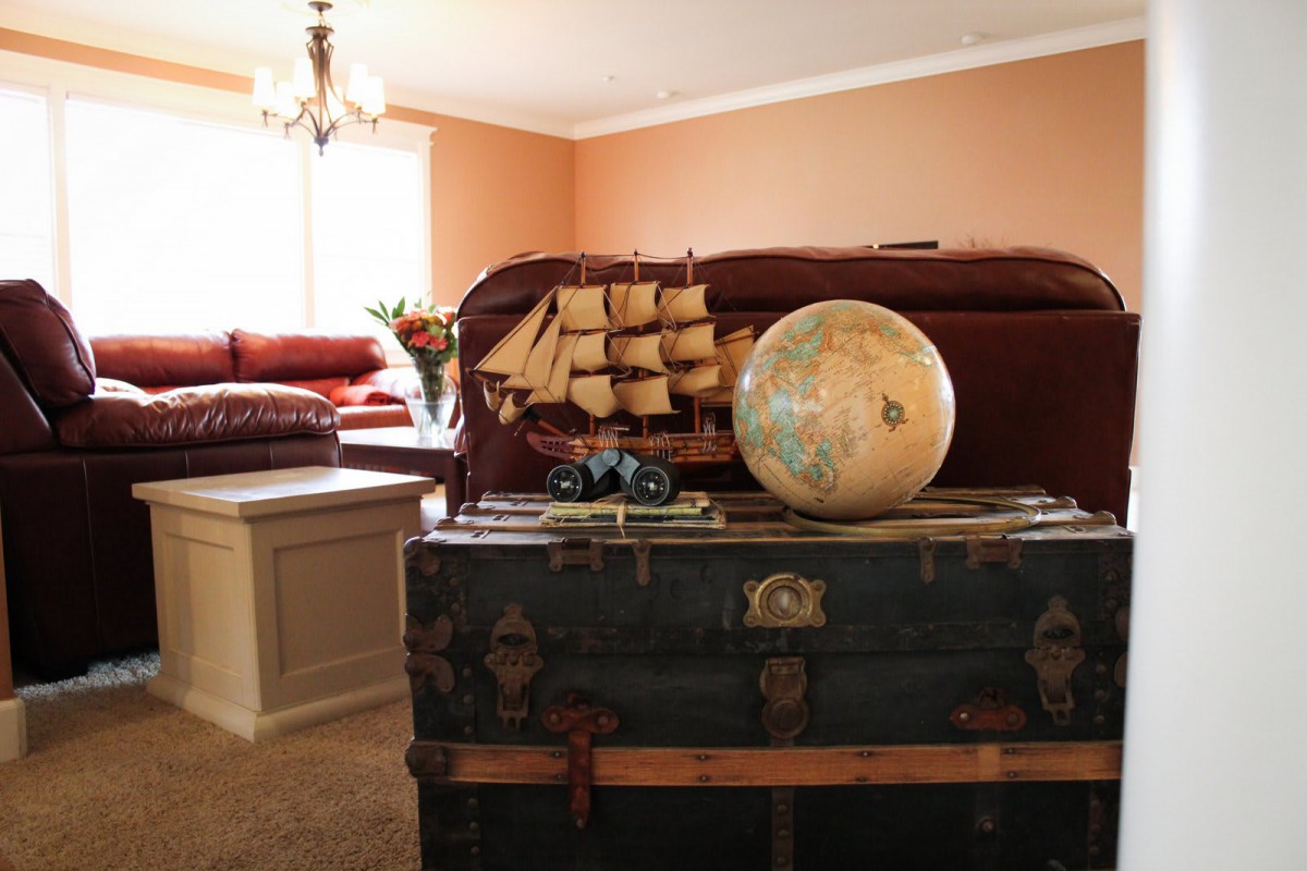 A cozy living room featuring a vintage trunk with a globe and model ship as decorative pieces.