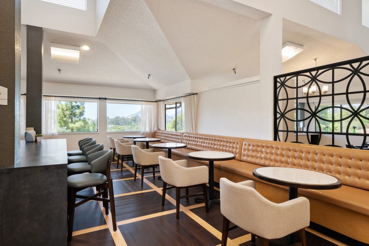 A modern dining area with natural light, featuring stylish tables and chairs.