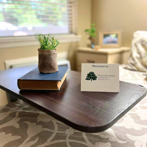 A cozy setup featuring a wooden side table with a book, a small potted plant, and an informational card.