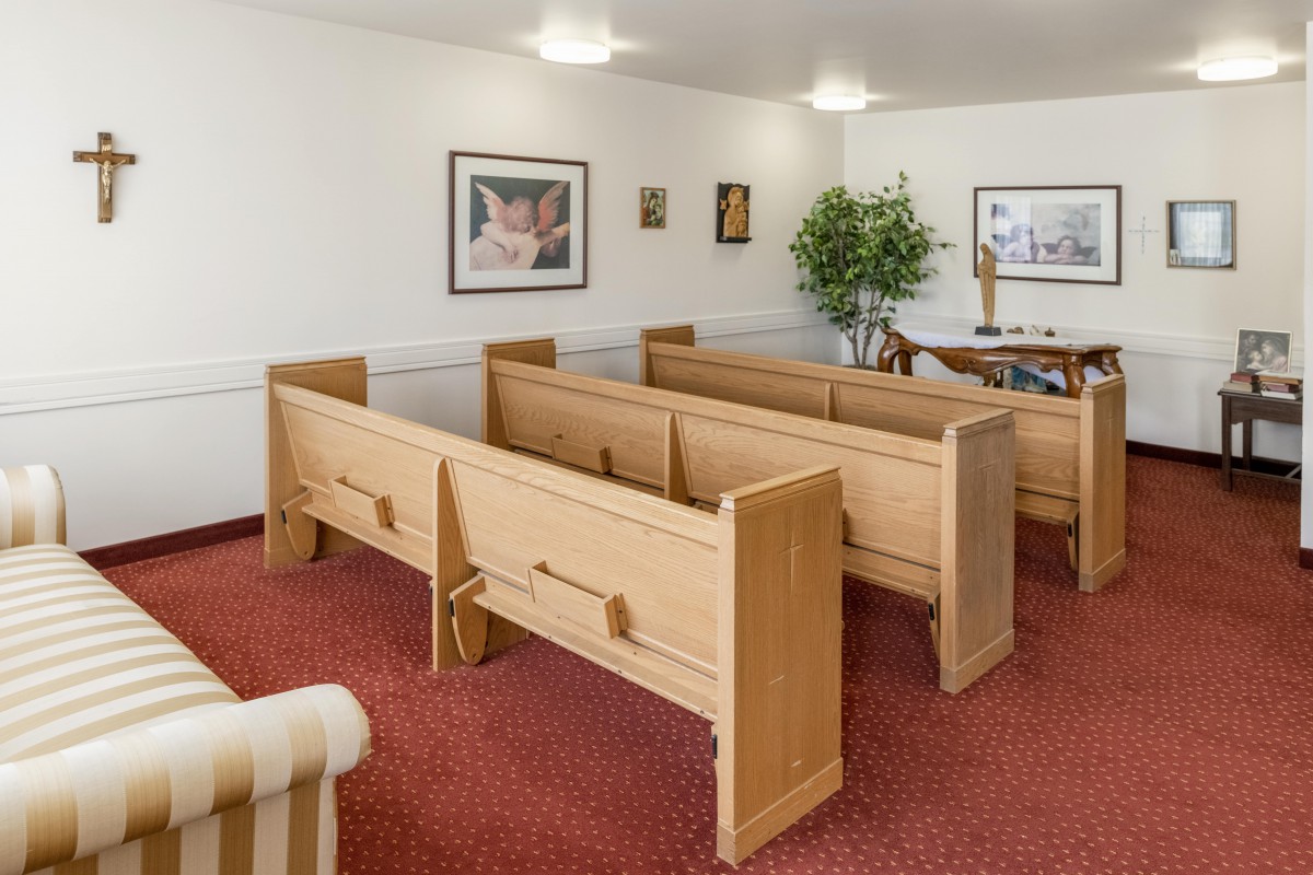 A small chapel interior with wooden pews and religious decor.