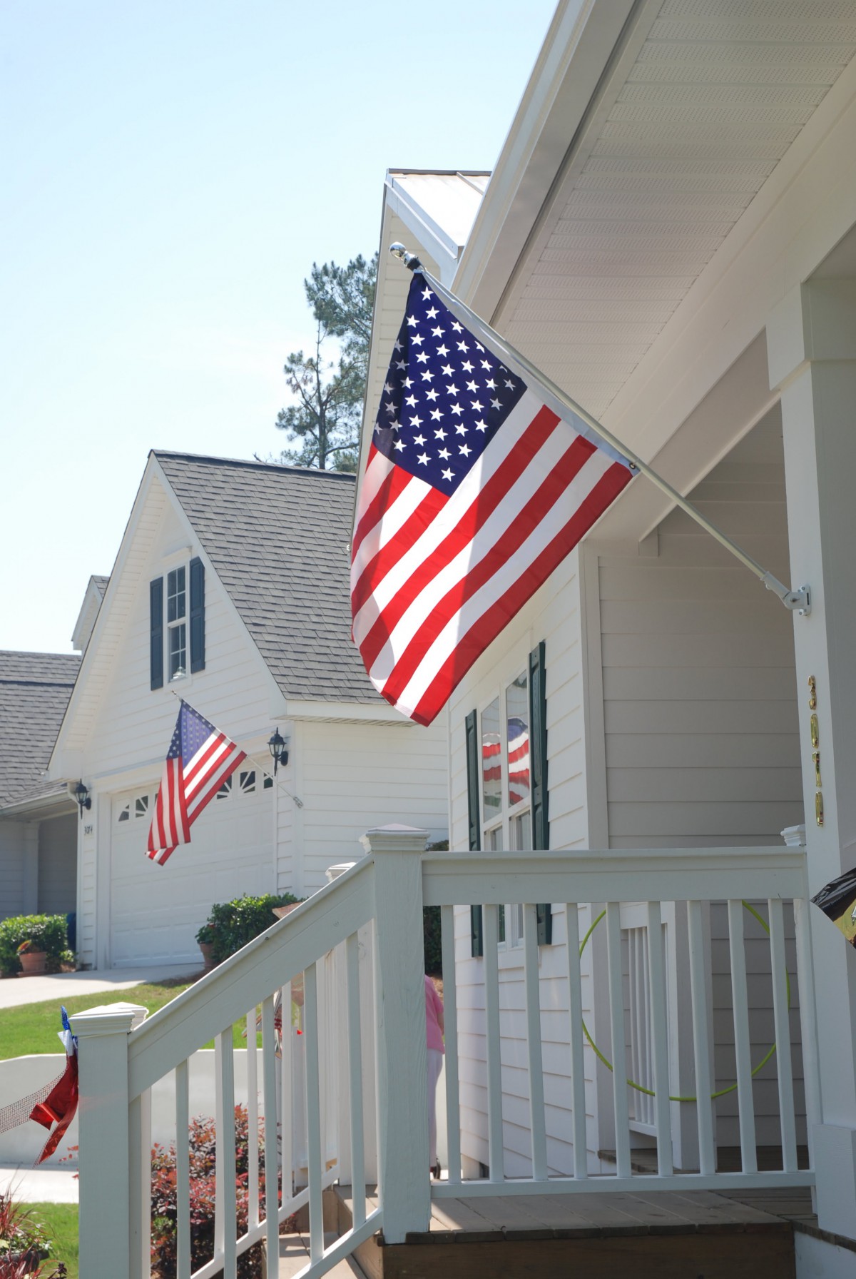 A suburban neighborhood displaying American flags on porches.