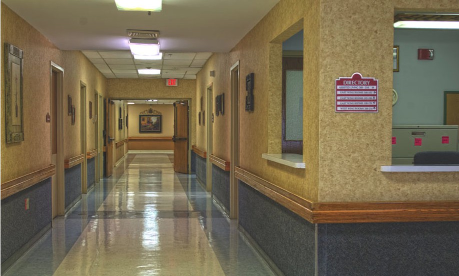 An empty hospital corridor with bright fluorescent lighting.