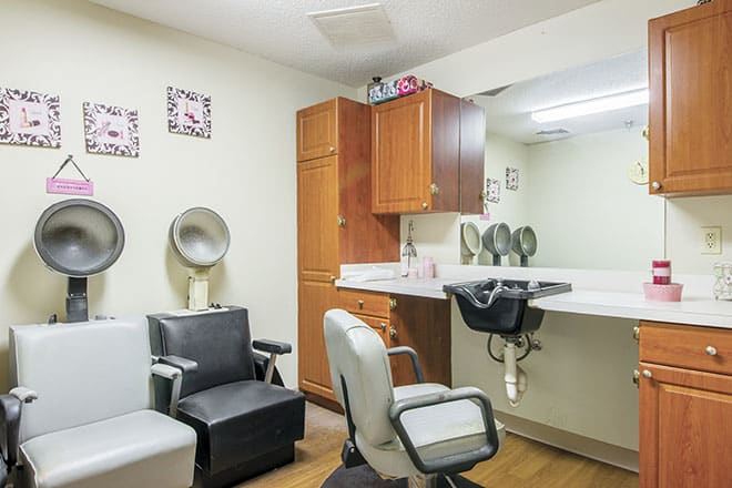 A cozy salon space equipped with styling chairs and a mirror.