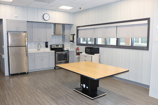 A modern kitchen breakroom featuring a central table and essential appliances.