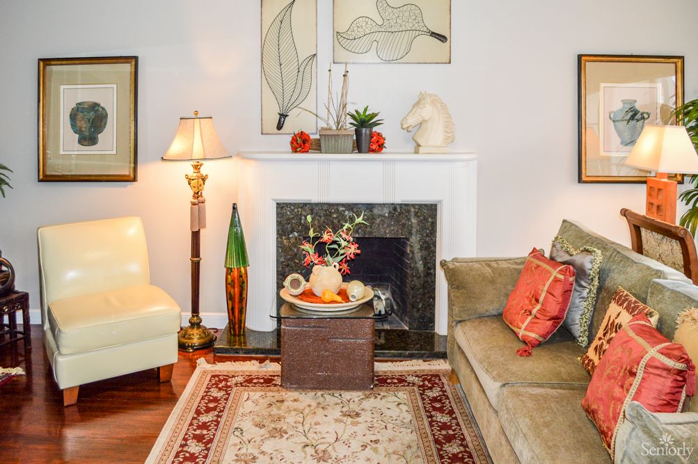 A cozy living room featuring a comfortable sofa, armchair, and a decorated fireplace.