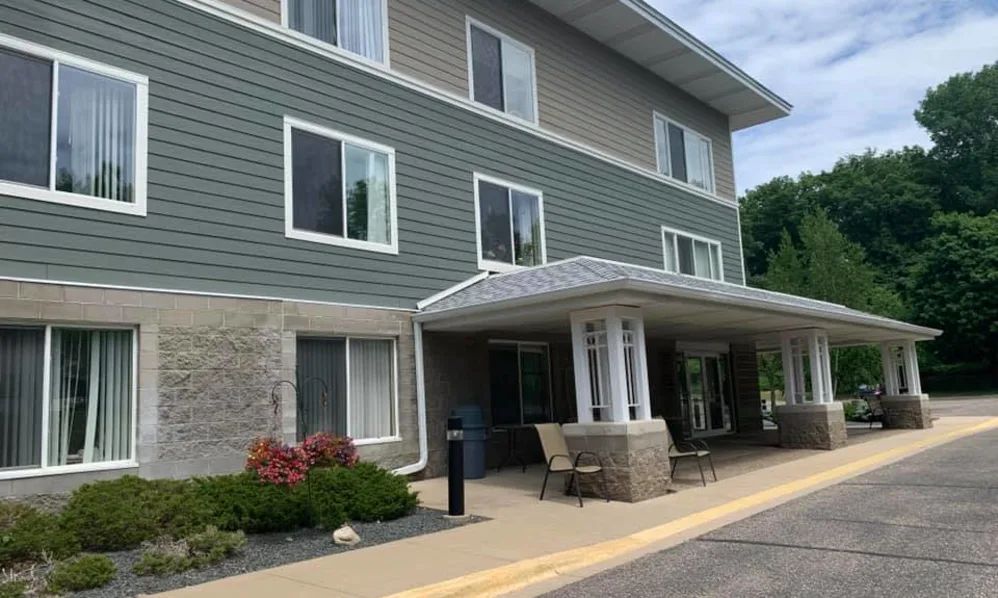 A modern three-story building with a landscaped entrance.