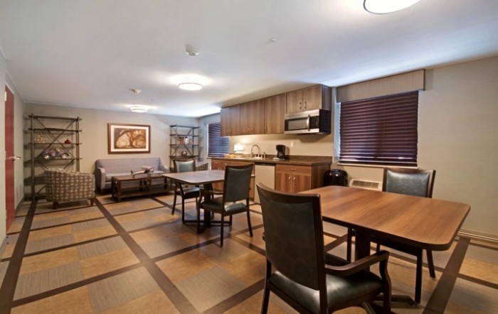 A modern kitchen and dining area with wooden tables and chairs.