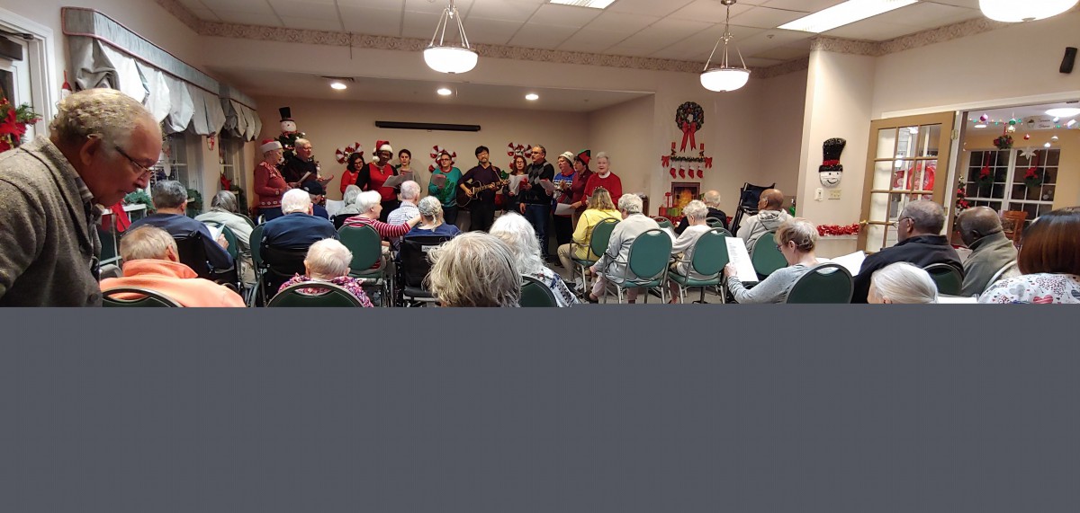 A choir performs for an audience in an indoor community setting.