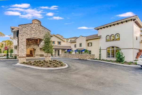 A luxurious residential building complex with a modern design and circular driveway.