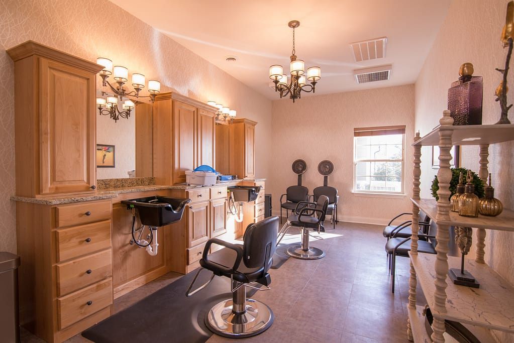 A well-lit hair salon with mirrors, chairs, and washing stations.