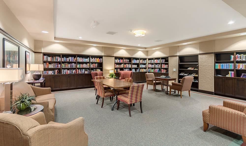 A cozy library reading room with bookshelves and comfortable seating.