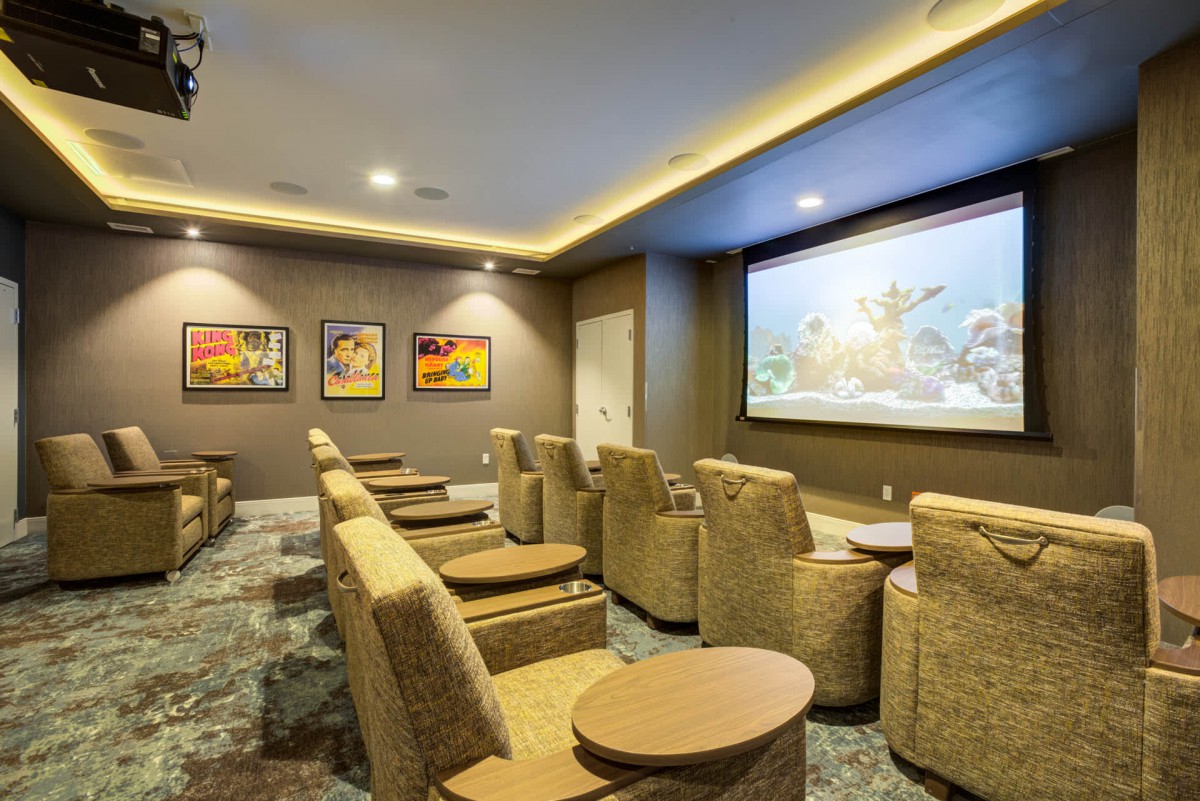 A cozy home theater room with comfortable seating and a large projector screen.