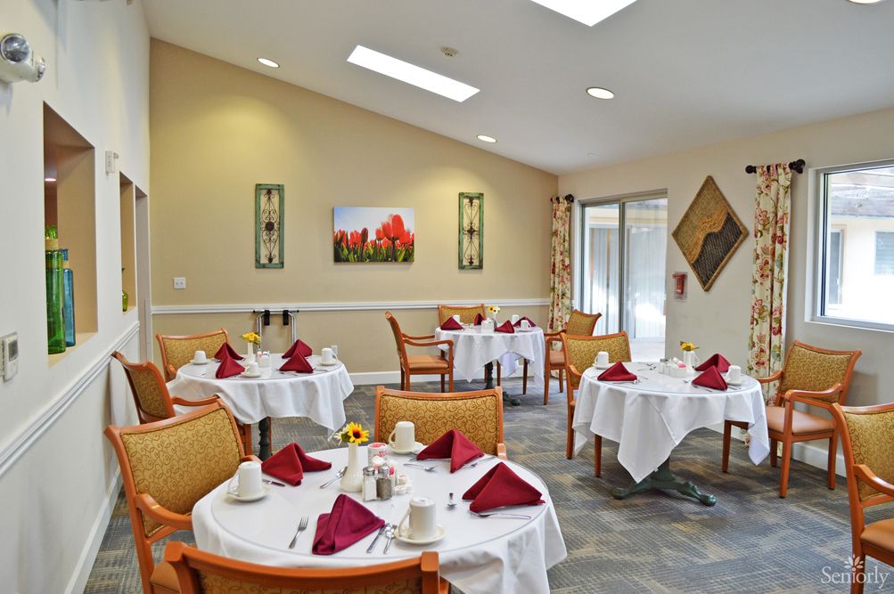 A formal dining area with neatly set tables and chairs.