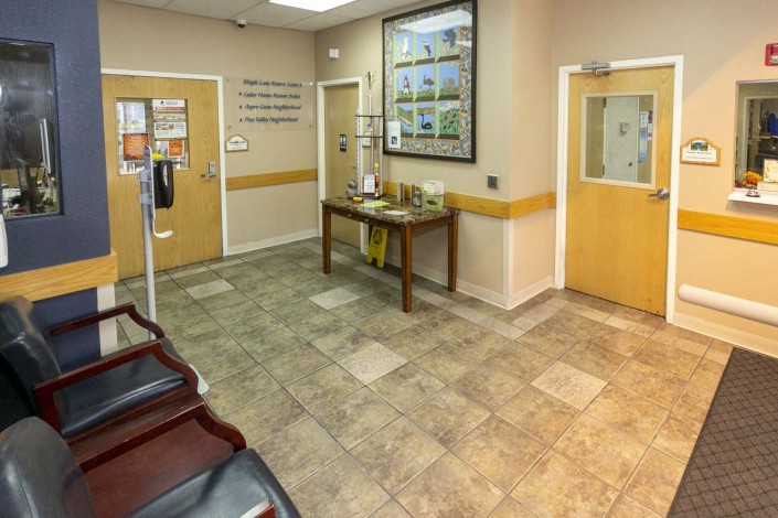 A clean and organized waiting room in a clinic with seating and informational displays.