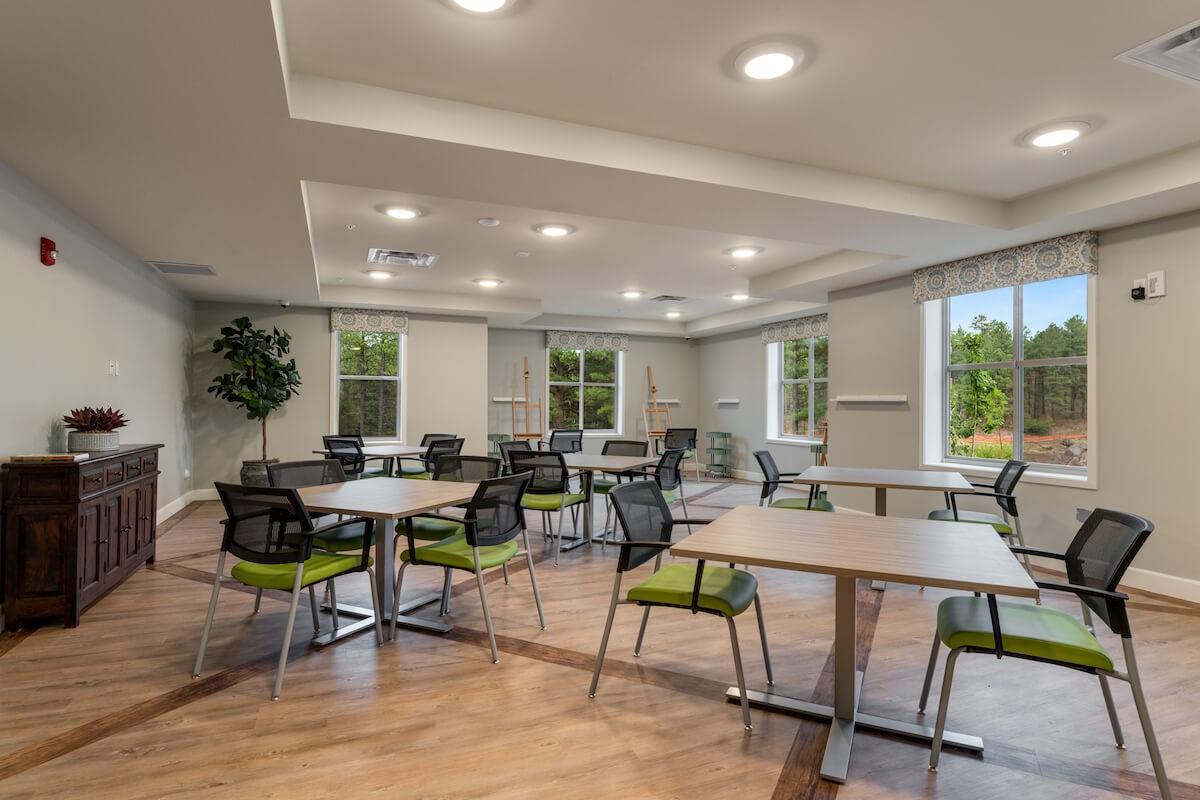 A modern conference room with tables, chairs, and bright lighting.