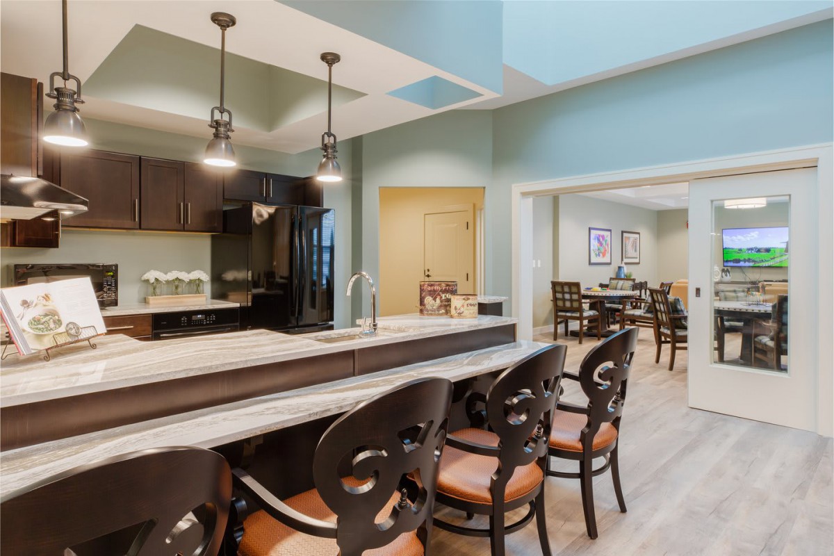 A modern kitchen and dining area with bar seating and stylish lighting.