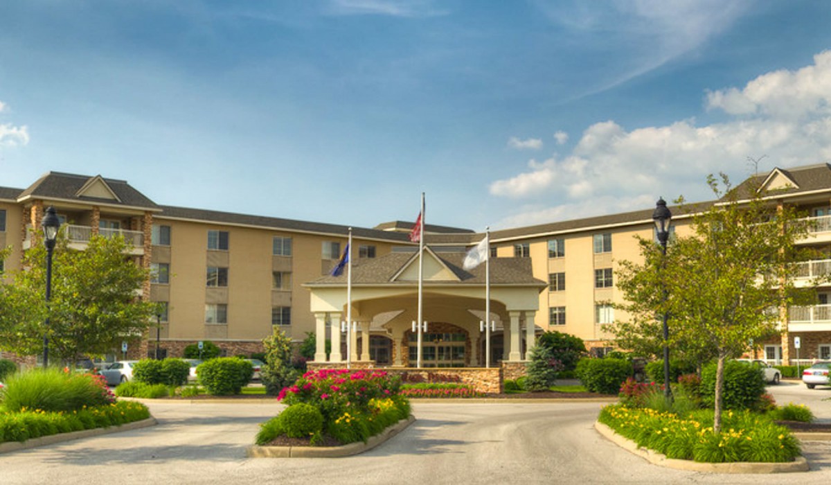 A scenic view of a large hotel entrance with flags and well-maintained landscaping.
