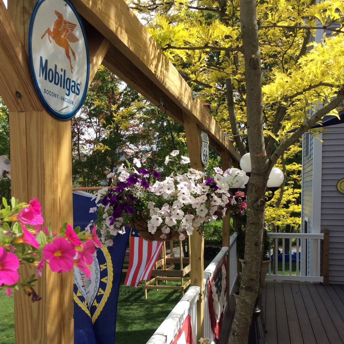 A vibrant garden patio with hanging flowers and a wooden structure adorned with decorations.