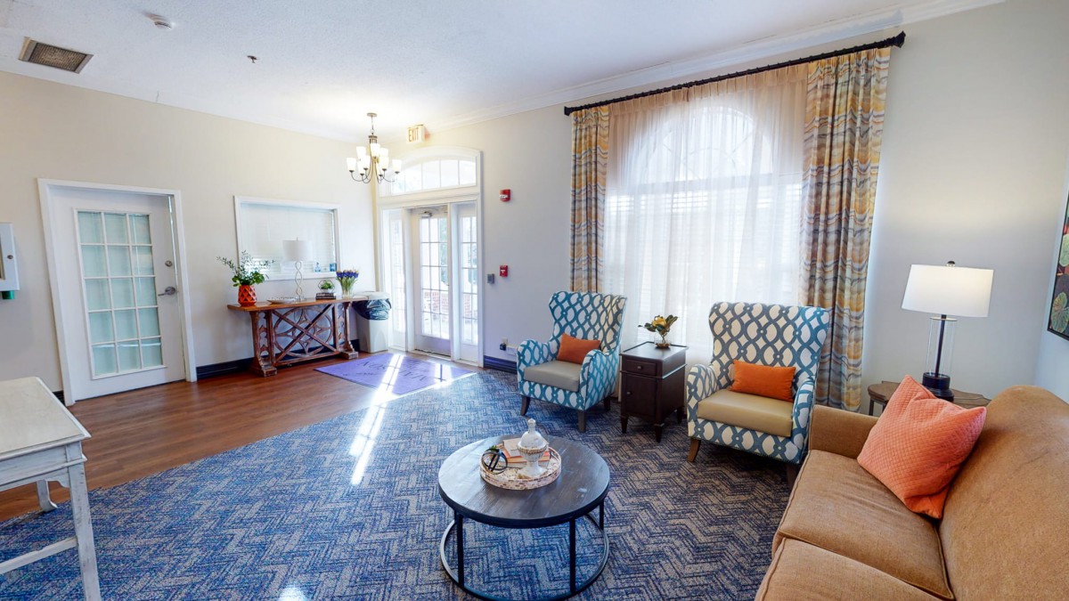 A cozy living room with stylish armchairs, a coffee table, and plenty of natural light.