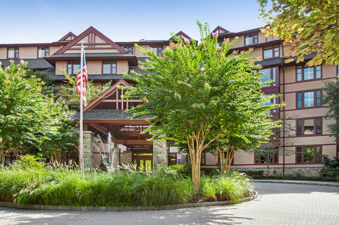 A scenic view of a hotel entrance surrounded by lush greenery.