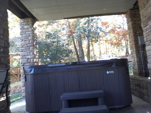A cozy hot tub nestled in a serene outdoor setting, surrounded by autumn foliage.