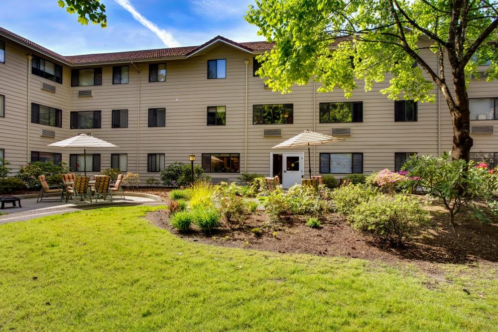 A well-maintained apartment building surrounded by landscaped gardens and greenery.
