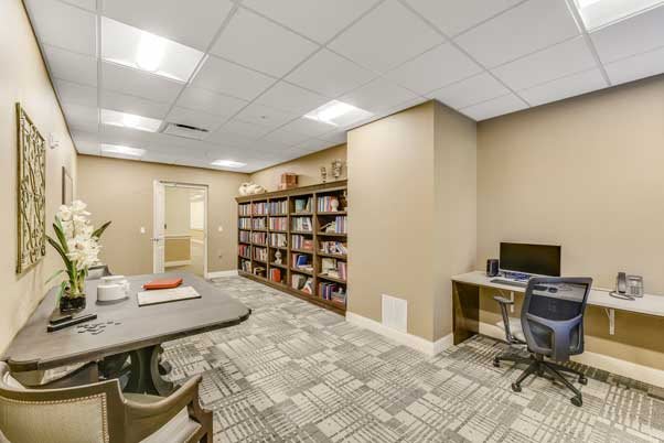 A cozy office space with a large bookshelf and computer desk.