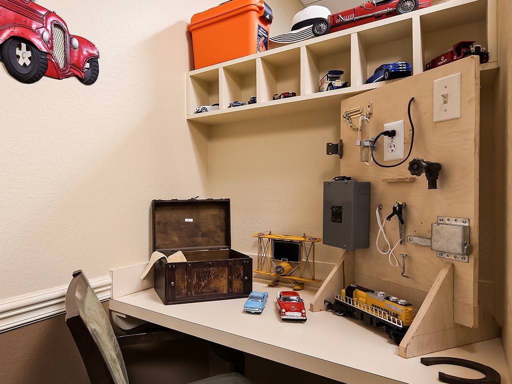 A small workshop space with toy cars, tools, and storage shelves.