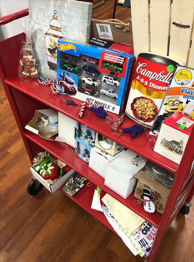 A red shelf displaying a variety of items including toys, food, and decorative pieces.