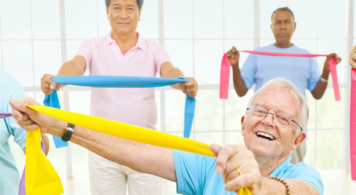 A group of seniors engaging in a fitness class using resistance bands, promoting a healthy and active lifestyle.