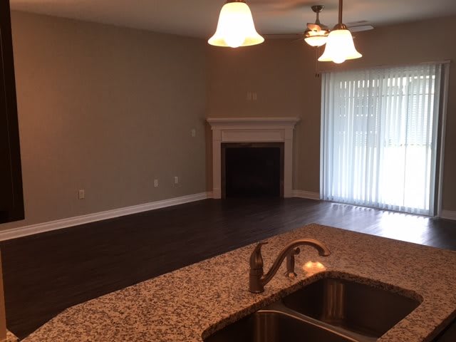 Open living space with a fireplace and kitchen view.
