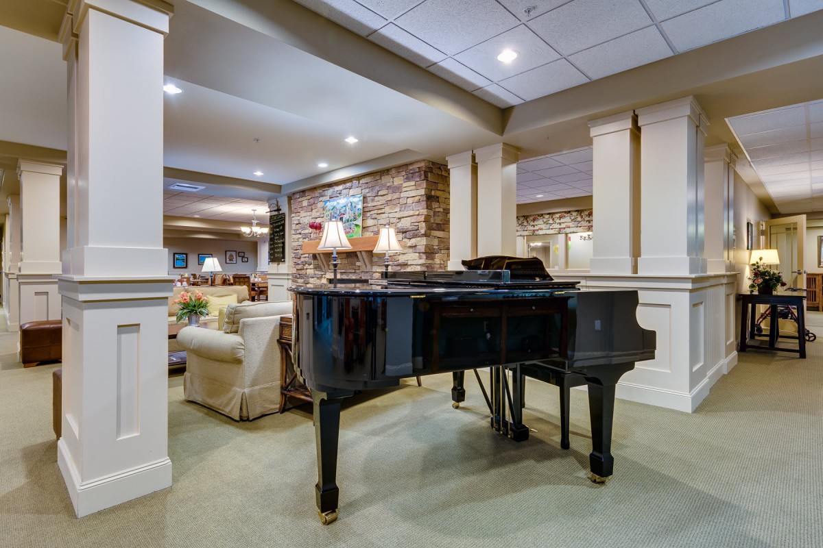 A luxurious living room featuring a grand piano and elegant interior design.