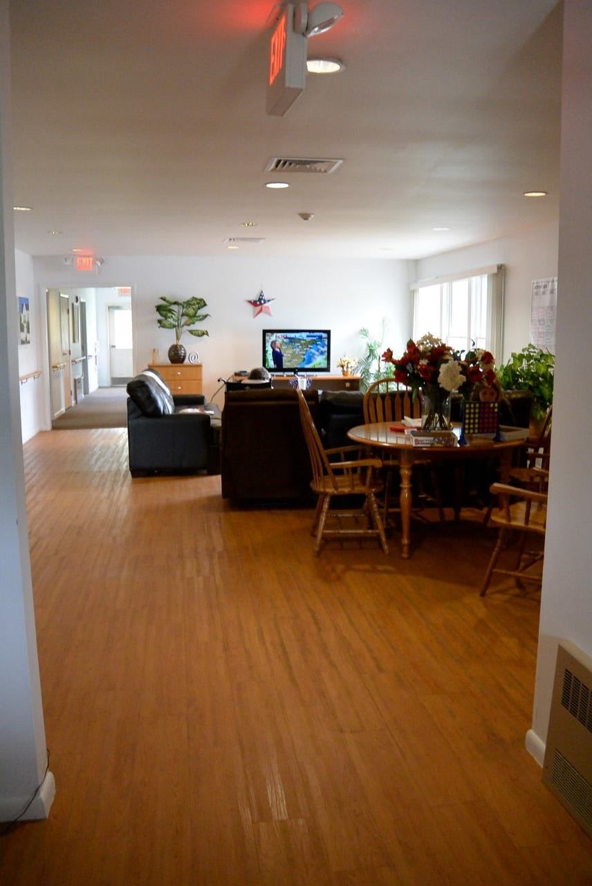 A cozy living room with sofas, a television, and a wooden dining table.