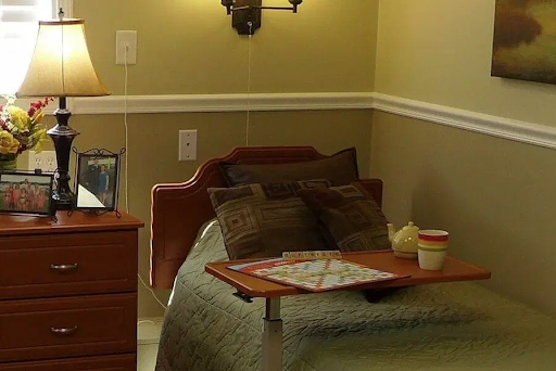 A cozy bedroom setup featuring a neatly made bed, decorative pillows, and a nightstand with a lamp.