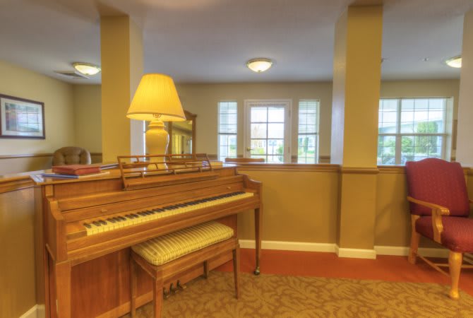 A cozy living room with a piano and warm lighting.