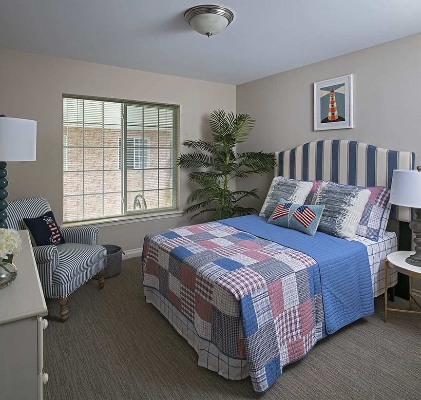 Cozy bedroom with a striped headboard and quilt.