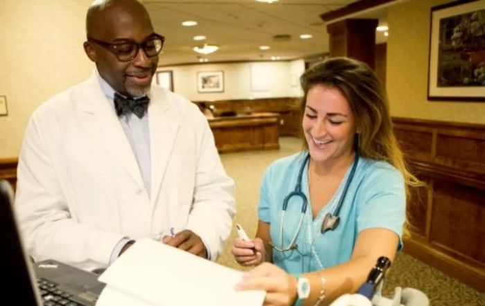 A doctor and a nurse discussing patient charts in a hospital setting.