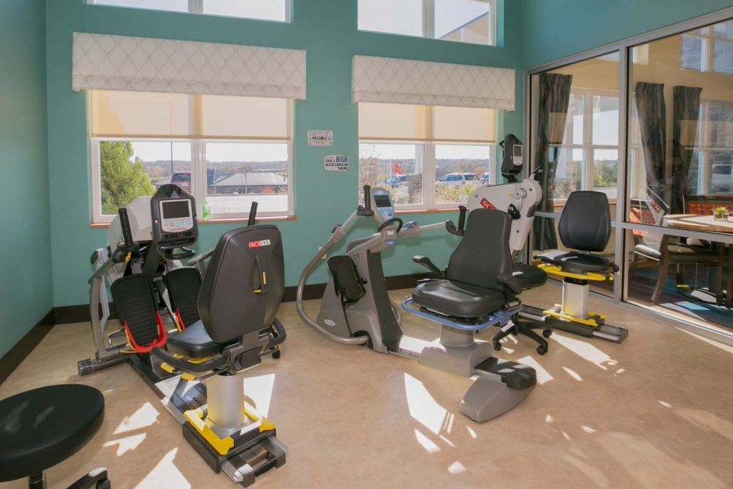 A bright and airy gym with various exercise equipment including stationary bikes.