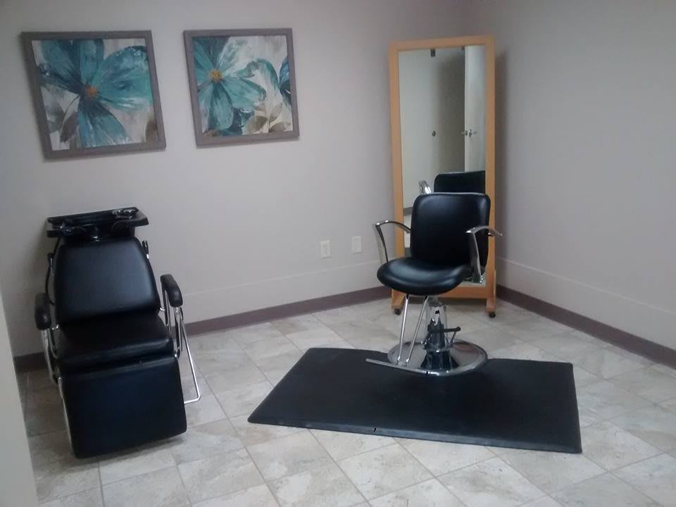 A clean and modern hair salon station with a styling chair and mirror.